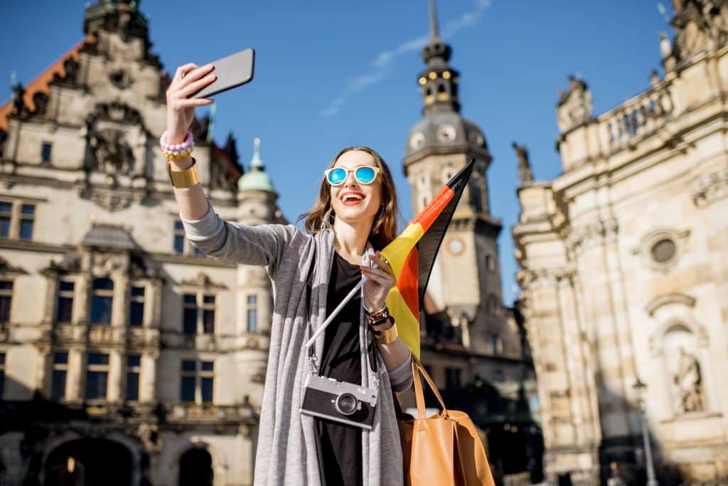 turista joven haciendo foto selfie bandera alemana casco antiguo dresde alemania